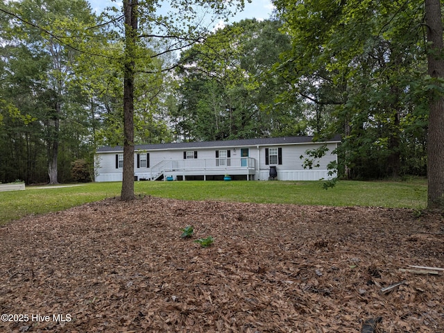manufactured / mobile home with a wooden deck and a front lawn