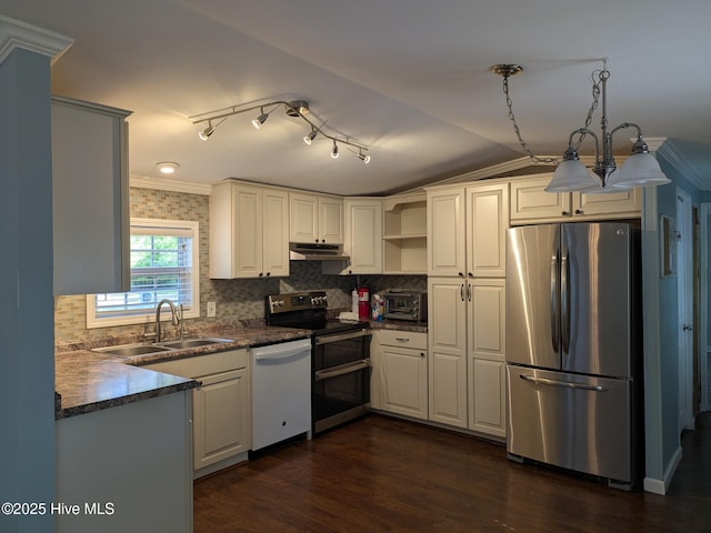 kitchen with a sink, appliances with stainless steel finishes, dark countertops, and ornamental molding