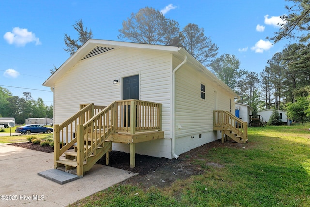 back of property with a yard and crawl space