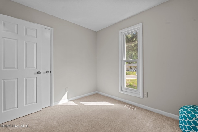 unfurnished bedroom with baseboards, carpet flooring, and visible vents