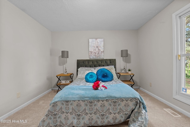 carpeted bedroom featuring visible vents, baseboards, and multiple windows