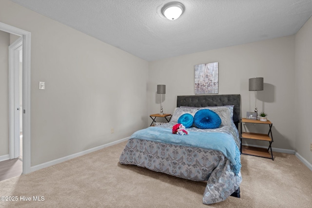 carpeted bedroom featuring baseboards and a textured ceiling