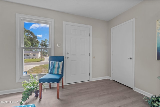 living area featuring baseboards and wood finished floors
