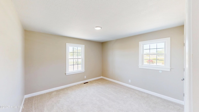 spare room featuring carpet floors and baseboards
