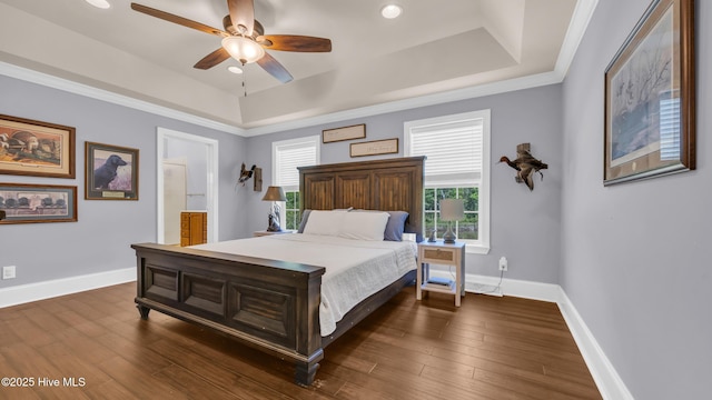 bedroom featuring a raised ceiling, baseboards, and dark wood-style floors