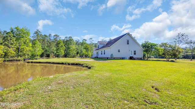view of side of home featuring a lawn and a water view