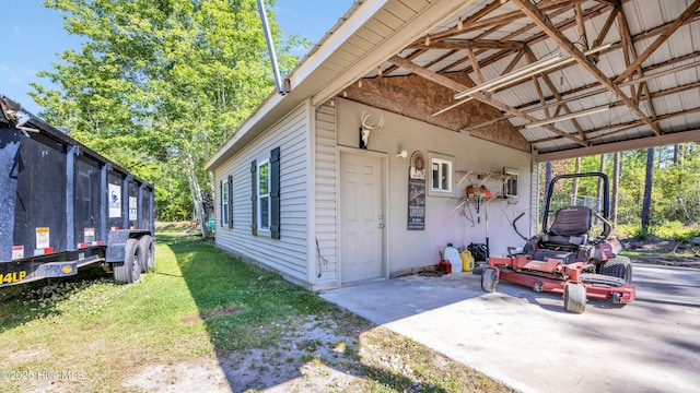 view of home's exterior with a carport, a yard, and a patio area