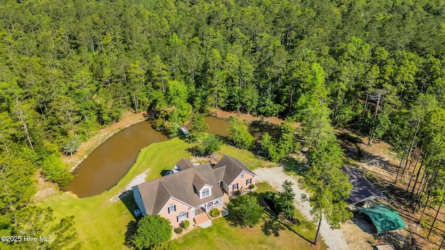 drone / aerial view featuring a forest view and a water view