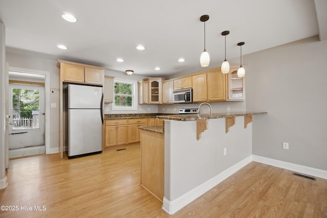 902 Hunnicutt Ave, Elizabeth City, NC 27909 - kitchen with stainless steel microwave, a peninsula, freestanding refrigerator, visible vents, and glass insert cabinets