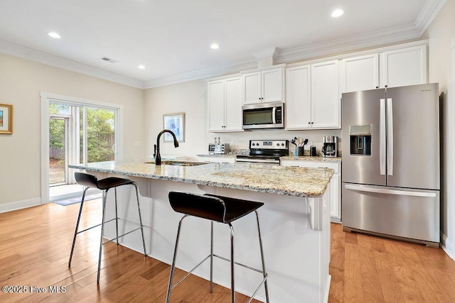 102 SW 8th St, Oak Island, NC 28465 - kitchen with a sink, a breakfast bar area, stainless steel appliances, and light wood-type flooring