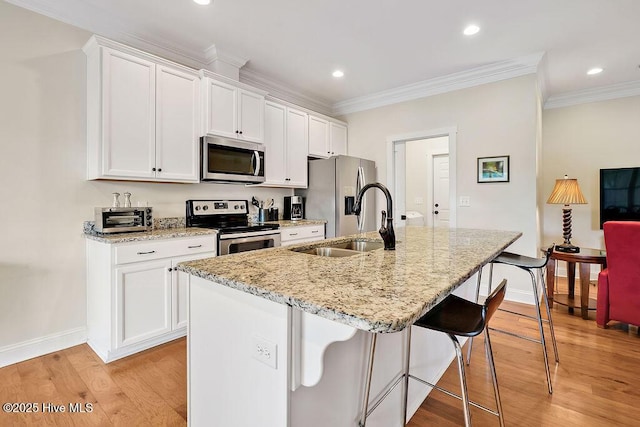 102 SW 8th St, Oak Island, NC 28465 - kitchen featuring appliances with stainless steel finishes, a sink, a kitchen breakfast bar, baseboards, and ornamental molding