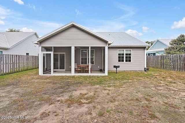 102 SW 8th St, Oak Island, NC 28465 - rear view of house with a fenced backyard, a sunroom, and metal roof
