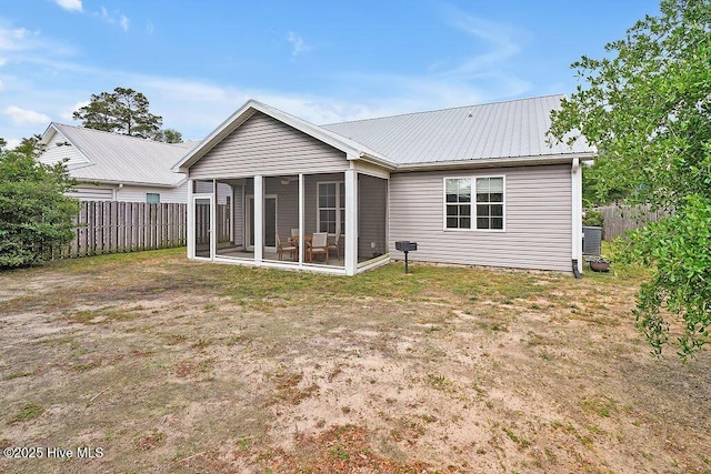102 SW 8th St, Oak Island, NC 28465 - rear view of house with a sunroom, fence, and metal roof