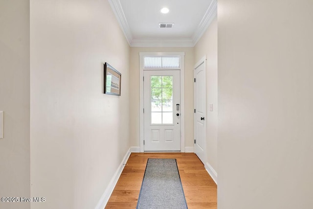 102 SW 8th St, Oak Island, NC 28465 - doorway with baseboards, visible vents, ornamental molding, and light wood-style floors