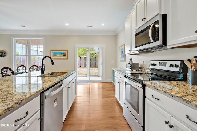 102 SW 8th St, Oak Island, NC 28465 - kitchen with visible vents, a sink, ornamental molding, stainless steel appliances, and white cabinetry