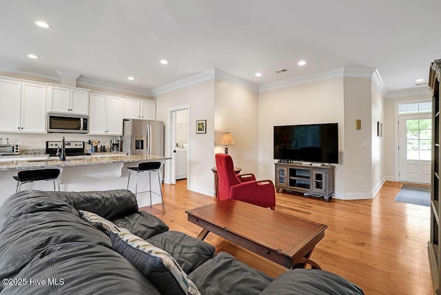 102 SW 8th St, Oak Island, NC 28465 - living room featuring light wood-style floors, recessed lighting, baseboards, and crown molding
