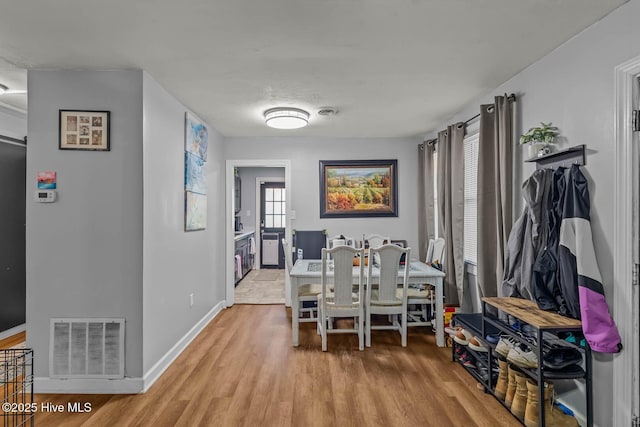 dining space featuring baseboards, wood finished floors, and visible vents