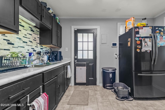 kitchen with light countertops, dark cabinetry, and freestanding refrigerator