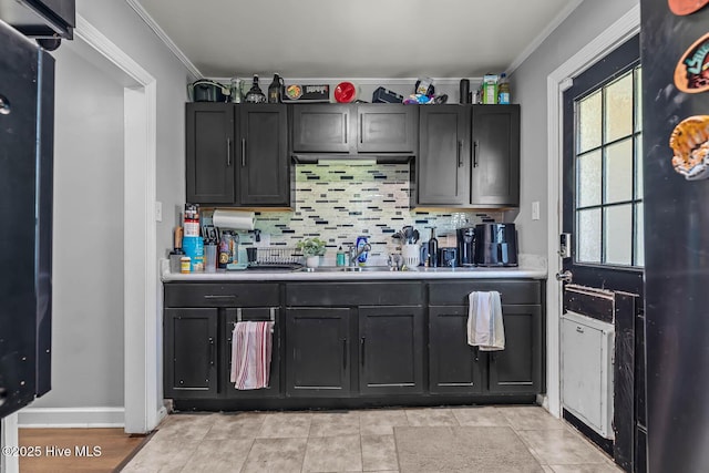 bar with a sink, decorative backsplash, ornamental molding, and baseboards