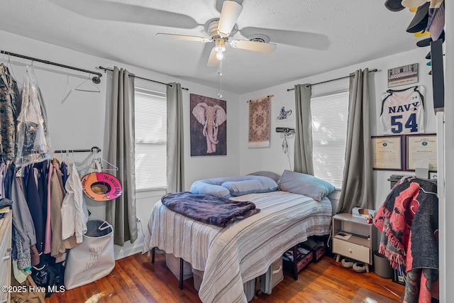bedroom featuring a textured ceiling, a ceiling fan, and wood finished floors