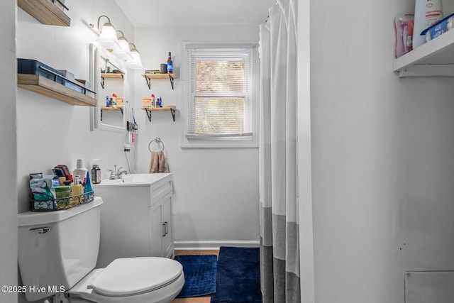 bathroom with vanity, baseboards, toilet, and wood finished floors