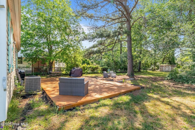 view of yard featuring a shed, an outdoor structure, central air condition unit, and a deck