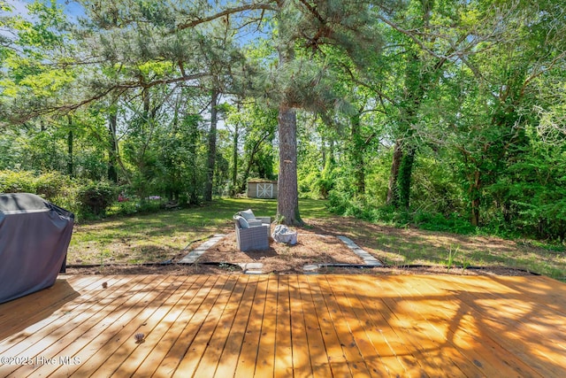 deck with a storage unit, an outdoor structure, and grilling area