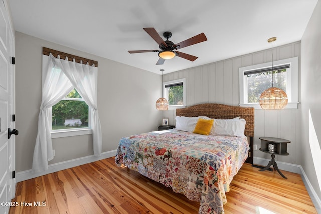 bedroom with baseboards, ceiling fan, and wood finished floors