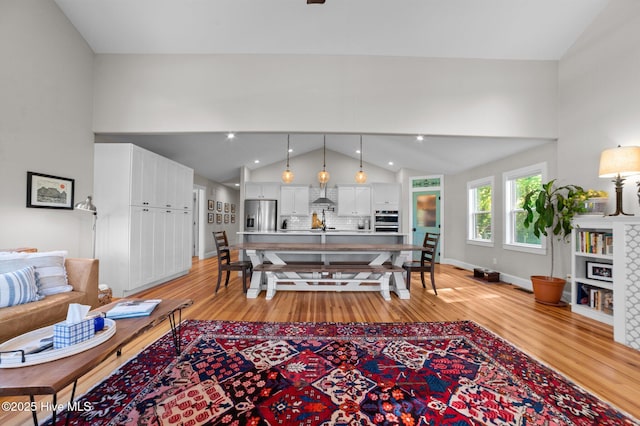 living room with light wood-style floors and lofted ceiling