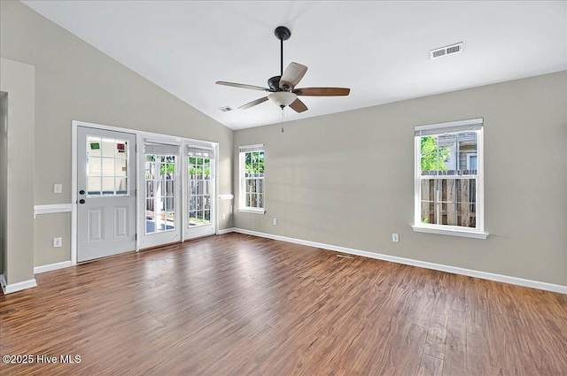 empty room featuring a ceiling fan, a wealth of natural light, and wood finished floors