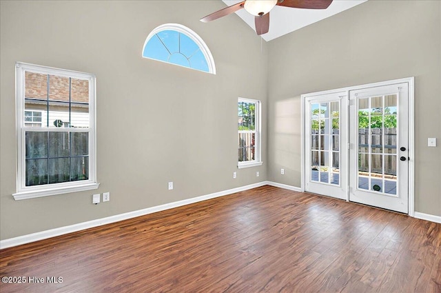 spare room featuring baseboards, ceiling fan, high vaulted ceiling, and wood finished floors