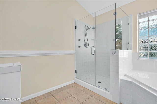 bathroom featuring tile patterned floors, baseboards, a stall shower, and a bath