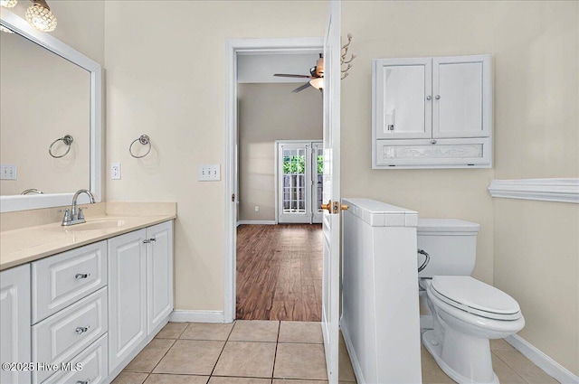 bathroom with baseboards, ceiling fan, toilet, and tile patterned flooring