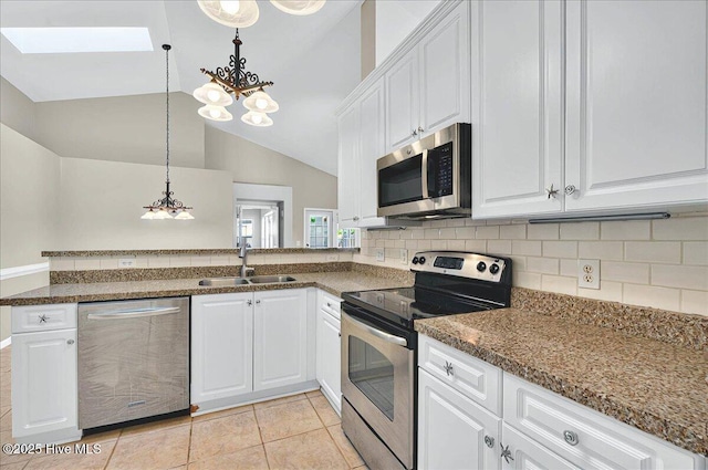 kitchen featuring appliances with stainless steel finishes, a sink, a chandelier, white cabinetry, and lofted ceiling