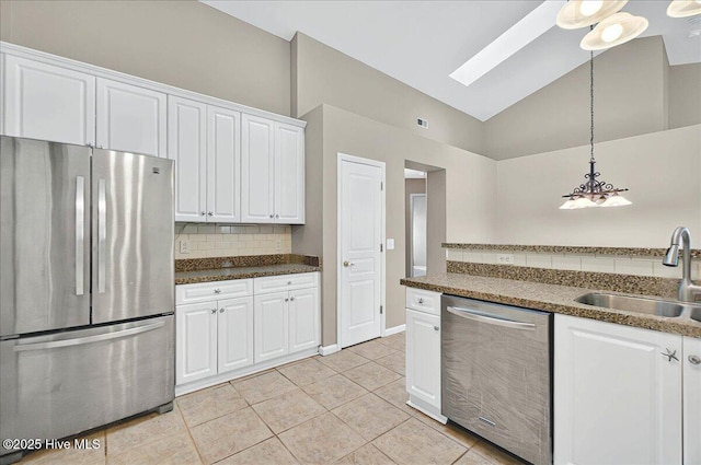 kitchen with decorative backsplash, light tile patterned flooring, white cabinetry, a sink, and appliances with stainless steel finishes