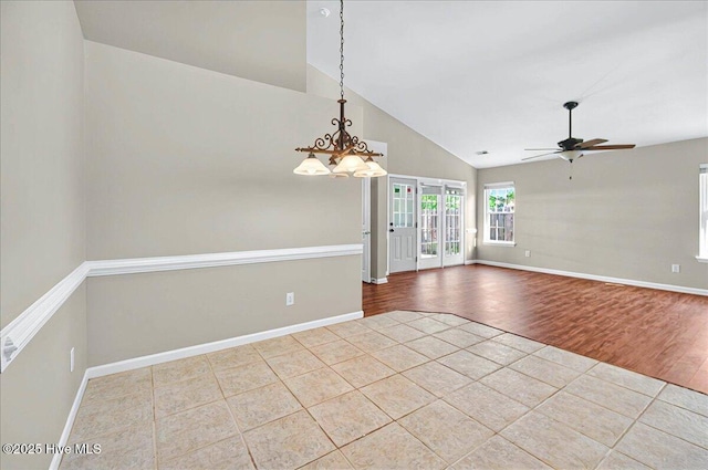 tiled spare room with high vaulted ceiling, baseboards, and ceiling fan with notable chandelier