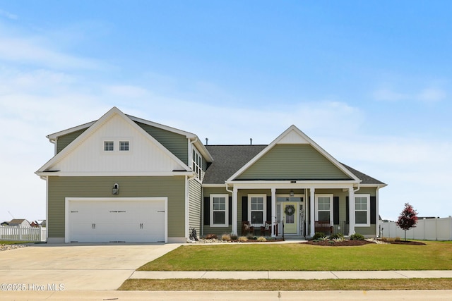 craftsman inspired home with a porch, fence, a front lawn, concrete driveway, and an attached garage