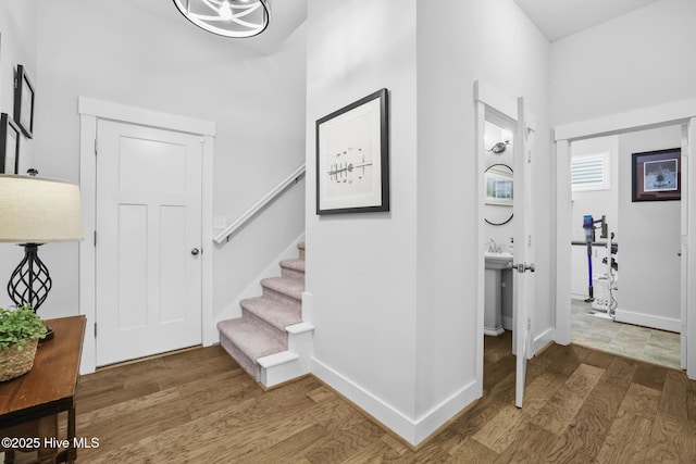 entrance foyer with stairs, baseboards, and wood finished floors