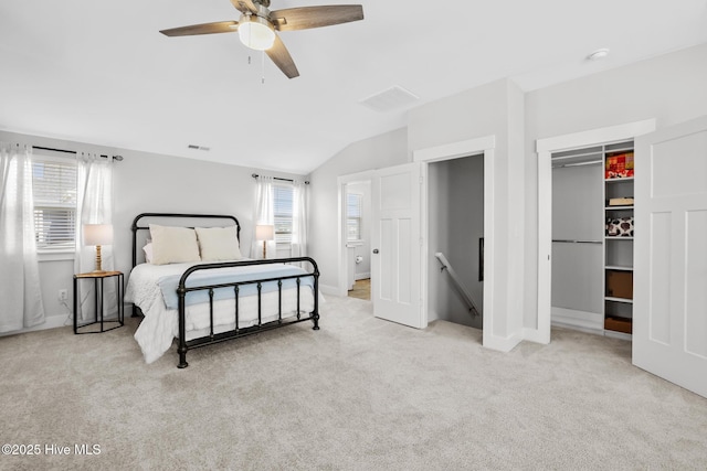 bedroom featuring a ceiling fan, visible vents, vaulted ceiling, a spacious closet, and carpet flooring