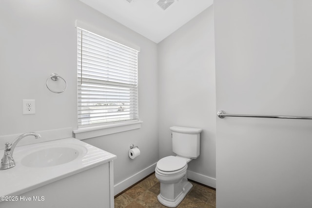 bathroom featuring baseboards, vanity, toilet, and visible vents
