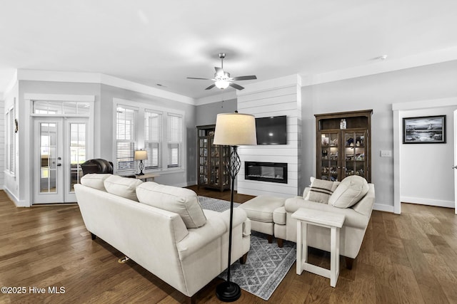 living room featuring baseboards, wood finished floors, and a fireplace