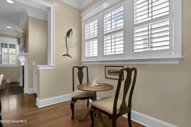 dining room featuring a fireplace, wood finished floors, baseboards, ornamental molding, and recessed lighting
