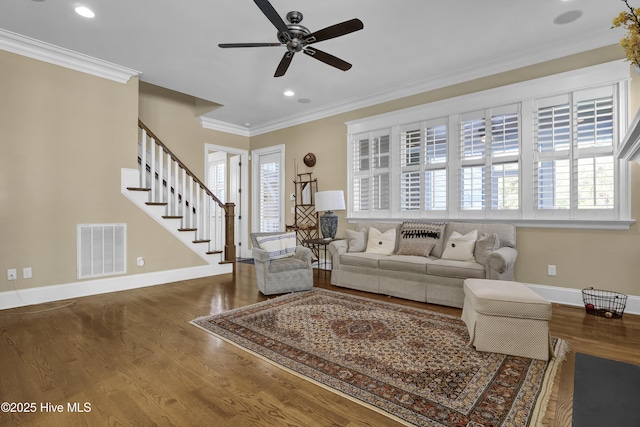 living area featuring stairway, baseboards, crown molding, and visible vents
