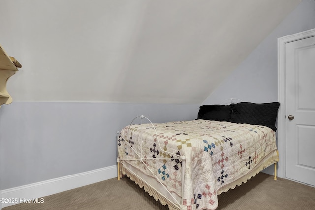 carpeted bedroom featuring baseboards and lofted ceiling