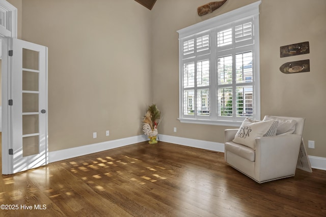 unfurnished room featuring baseboards, wood finished floors, and visible vents
