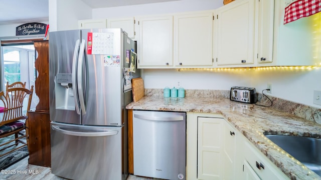 kitchen featuring a sink, appliances with stainless steel finishes, and white cabinets