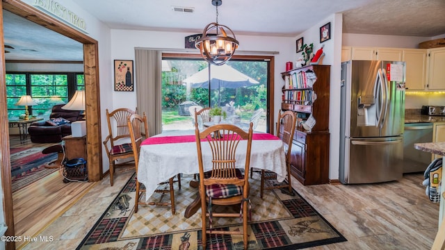 dining area with visible vents, a notable chandelier, and a wealth of natural light