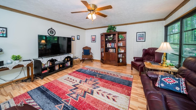 living area with ornamental molding, a textured ceiling, ceiling fan, and wood finished floors