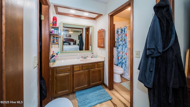 ensuite bathroom featuring vanity, wood finished floors, toilet, ensuite bathroom, and a shower with shower curtain
