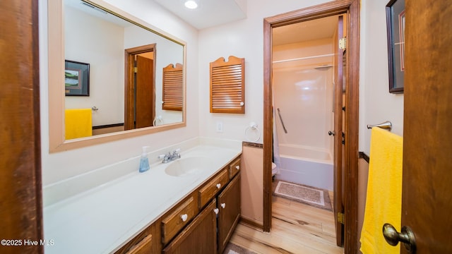 bathroom featuring wood finished floors, shower / bath combo, and vanity